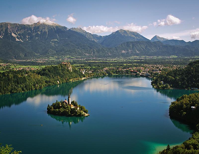Iconic view of Lake Bled with its island and castle, a breathtaking destination on a Helia self-guided cycling tour in Slovenia.