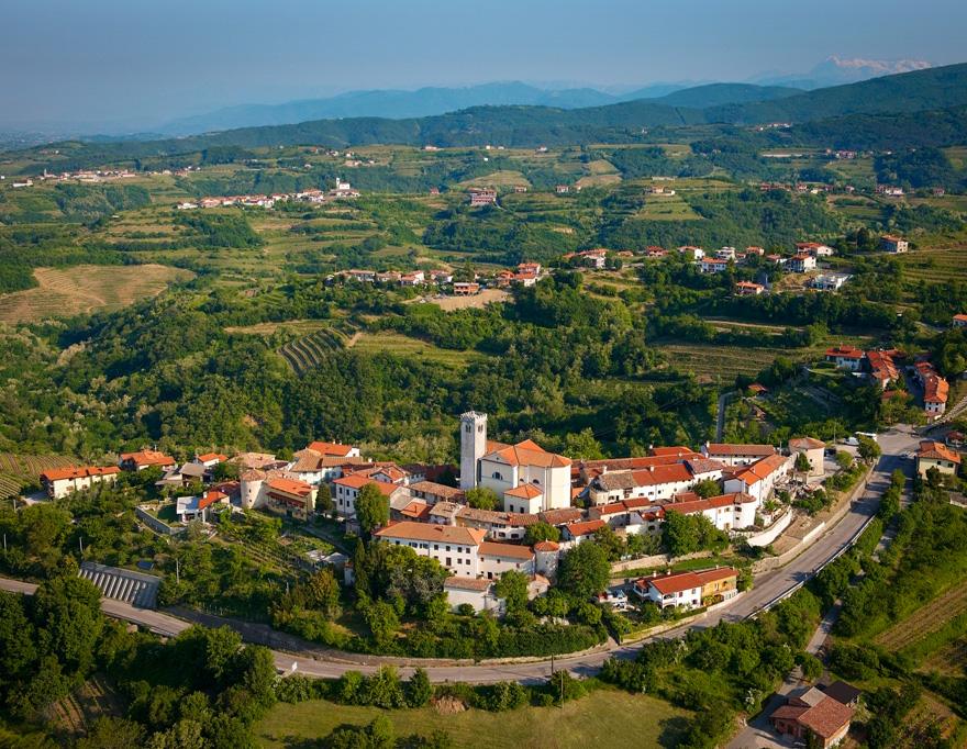 Scenic view of the rolling vineyards and a hilltop village in Goriška Brda, the heart of Slovenia's wine country, explored on a Helia self-guided bike tour.